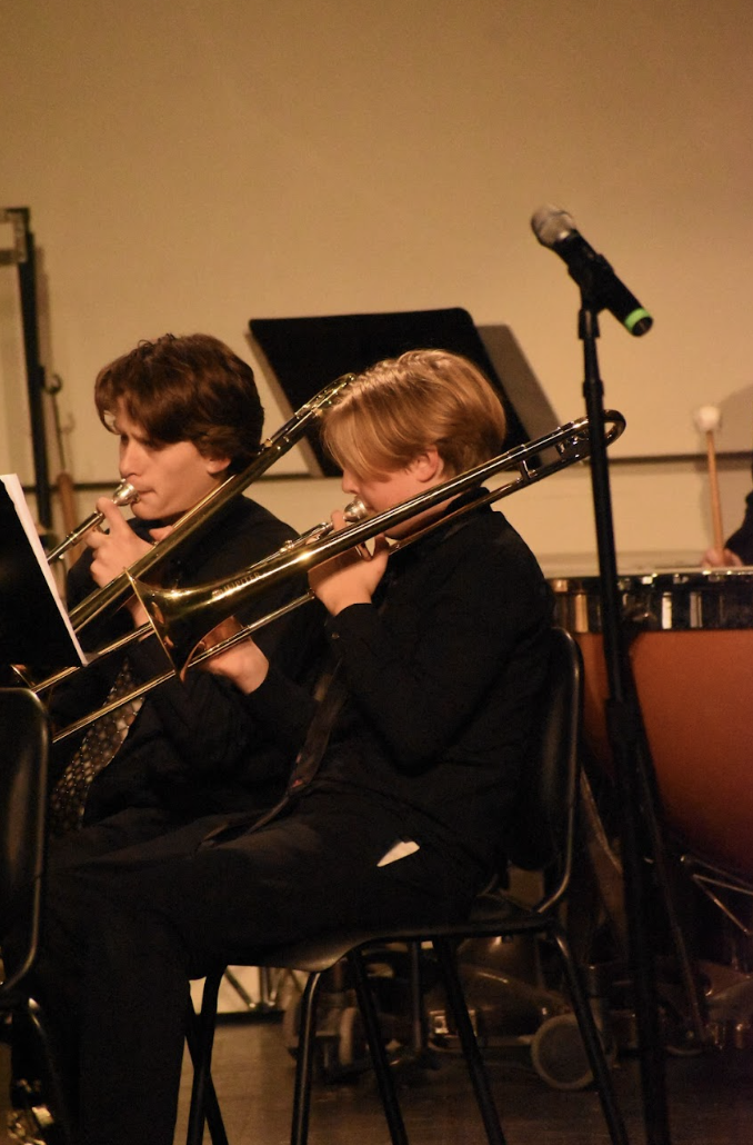 Elijah Hamm (9) and Myles Yeager (9) play the trombone at the winter band concert in the Highlands High School PAC. 